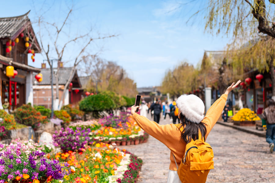 niña turista saltando en un jardín en China